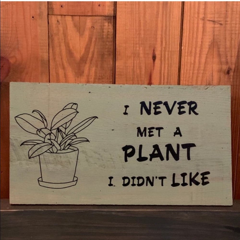 Wooden painted sign with vinyl lettering: “I never met a plant I didn’t like”